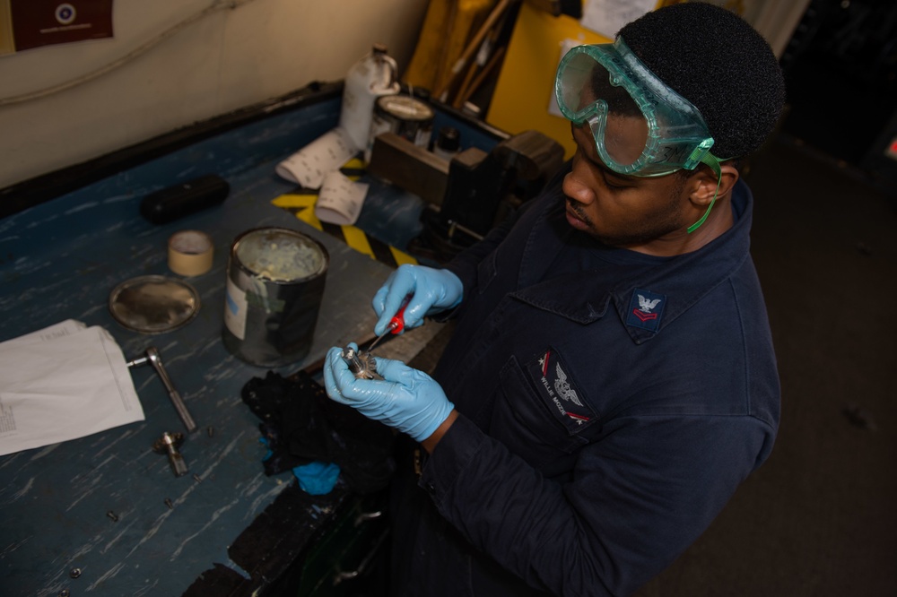 Aviation Support Equipment Technician 2nd Class Willie Mozie, from Alexandria, Louisiana, strips grease from a gear in the Gas Systems Equipment shop aboard the Nimitz-class aircraft carrier USS John C. Stennis (CVN 74).