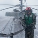 A Sailor removes a strap from an MH-60R Sea Hawk