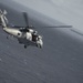 An MH-60S Knight Hawk, with Helicopter Sea Combat Squadron (HSC) 14, flies towards the Nimitz-class aircraft carrier USS John C. Stennis (CVN 74).