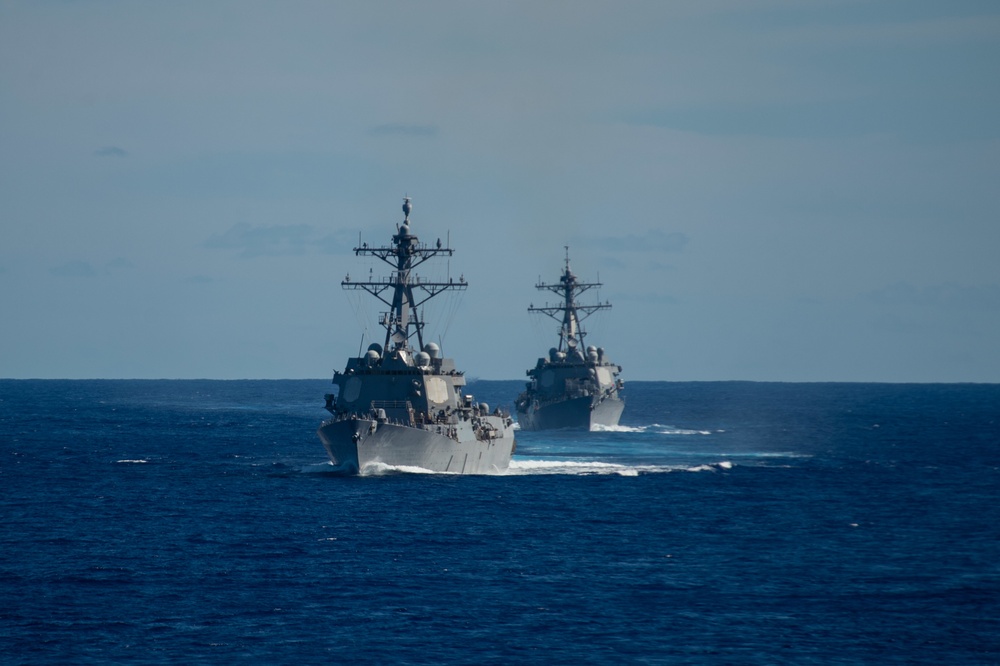 The Arleigh Burke-class guided-missile destroyers USS Chung-Hoon (DDG 93), left, and USS Spruance (DDG 111) cut through the Pacific Ocean.