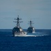 The Arleigh Burke-class guided-missile destroyers USS Chung-Hoon (DDG 93), left, and USS Spruance (DDG 111) cut through the Pacific Ocean.