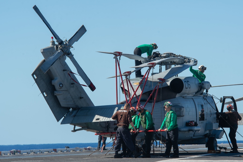 Sailors secure rotors on an MH-60R Sea Hawk, with Helicopter Maritime Strike Squadron (HSM) 71, on the flight deck aboard the Nimitz-class aircraft carrier USS John C. Stennis (CVN 74).