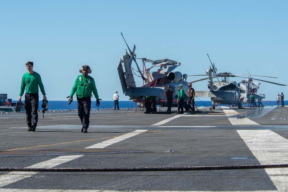 Sailors transit the flight deck before flight quarters aboard the Nimitz-class aircraft carrier USS John C. Stennis (CVN 74).
