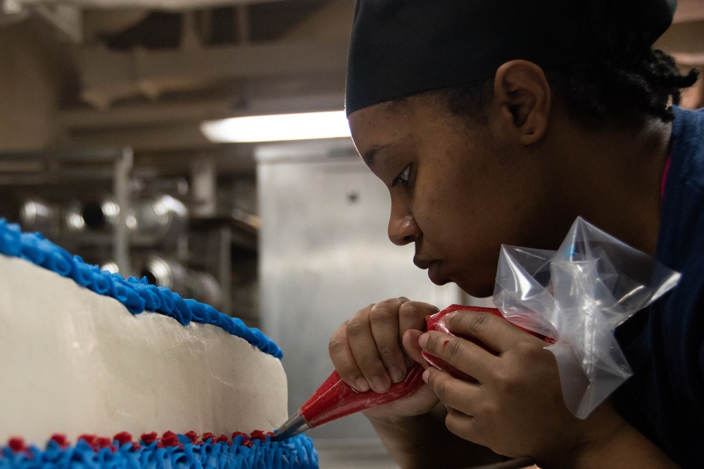 Culinary Specialist Seaman Apprentice Ayesha Coleman, from Woodbridge, Virginia, decorates a Veteran's Day cake aboard the Nimitz-class aircraft carrier USS John C. Stennis (CVN 74).