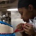 Culinary Specialist Seaman Apprentice Ayesha Coleman, from Woodbridge, Virginia, decorates a Veteran's Day cake aboard the Nimitz-class aircraft carrier USS John C. Stennis (CVN 74).