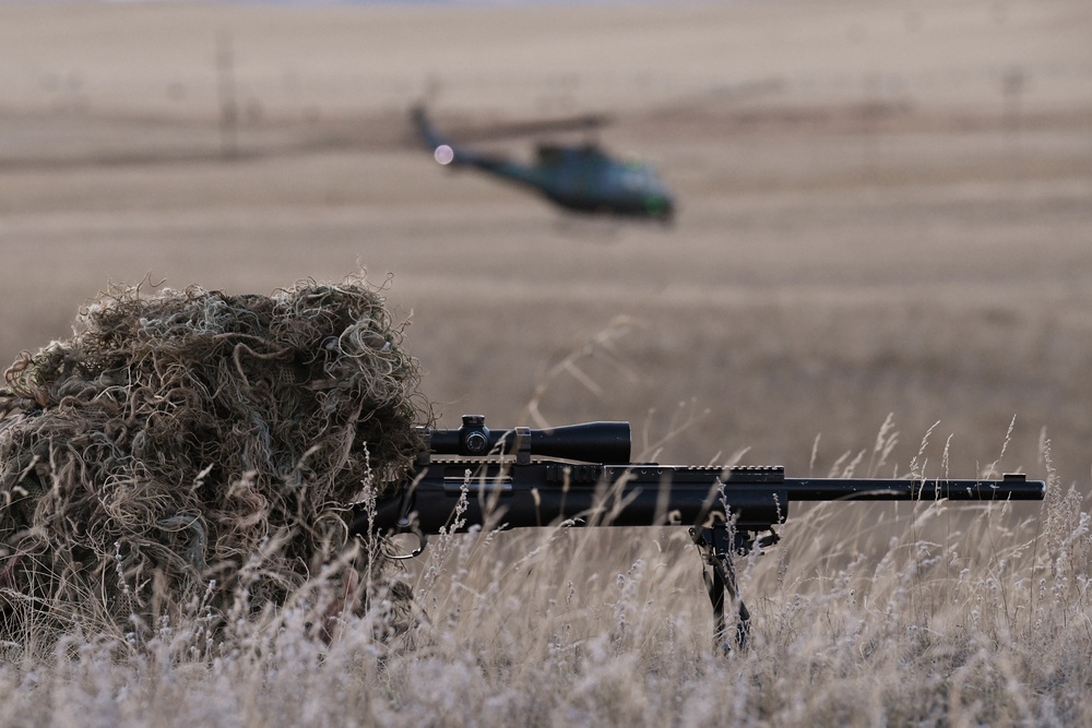 A nuclear advanced designated marksman from the 341st Security Support Squadron Tactical Response Force watches as a helicopter offloads other members in support of a launch facility recapture exercise during Global Thunder 19, Oct. 30, 2018