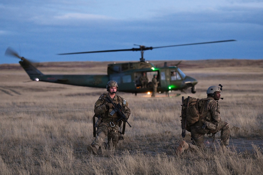 Members of the 341st Security Forces Group prepare to load a helicopter assigned to the 40th Helicopter Squadron during a launch facility recapture exercise during Global Thunder 19, Oct. 30, 2018