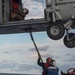 Sailors hook cargo to an MH-60S Sea Hawk, with Helicopter Sea Combat Squadron (HSC) 14, during a vertical replenishment-at-sea.