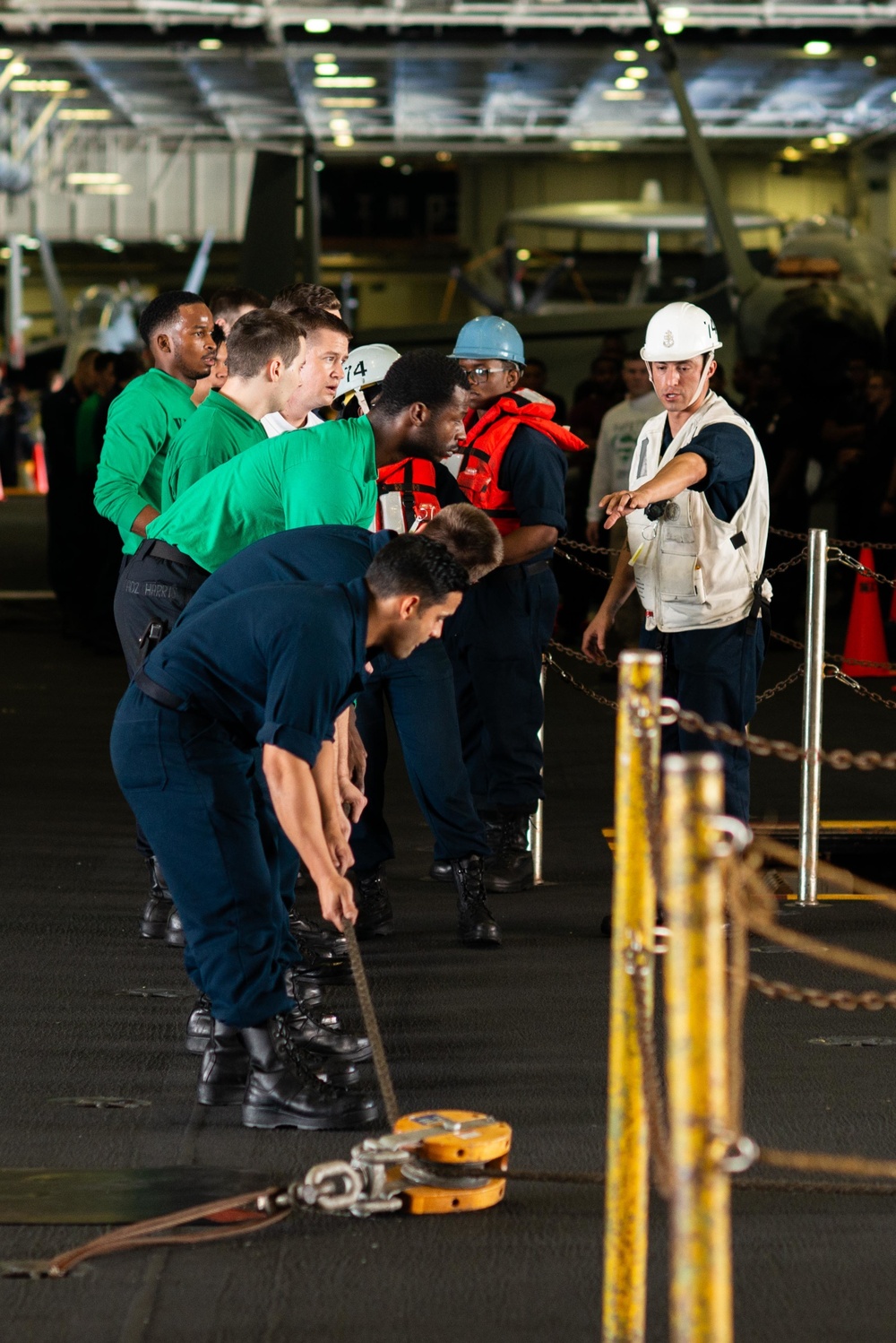Chief Boatswain's Mate Alfonso Guerrero instructs line handlers aboard the Nimitz-class aircraft carrier USS John C. Stennis (CVN 74) during a replenishment-at-sea evolution.