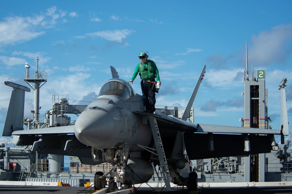 A Sailor prepares to dismount an F/A-18E Super Hornet, with Strike Fighter Squadron (VFA) 97, on the flight deck aboard the Nimitz-class aircraft carrier USS John C. Stennis (CVN 74).