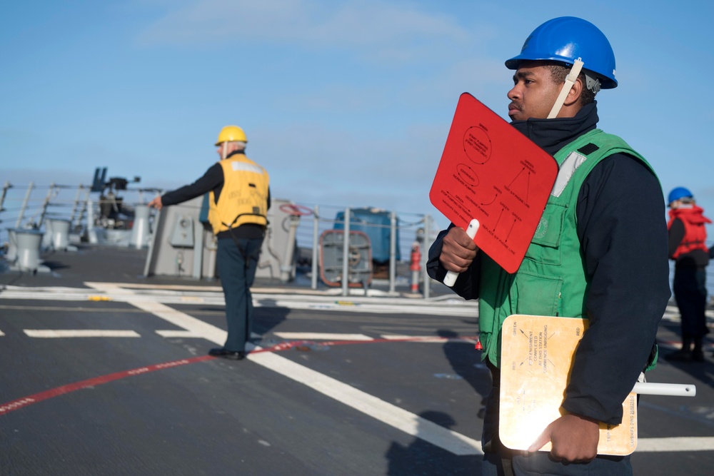 Culinary Specialist 2nd Class Delon Hurd, from Jackson, Michigan, communicates with the Military Sealift Command (MSC) fleet replenishment oiler USNS Guadalupe (T-AO 200) during a replenishment-at-sea.