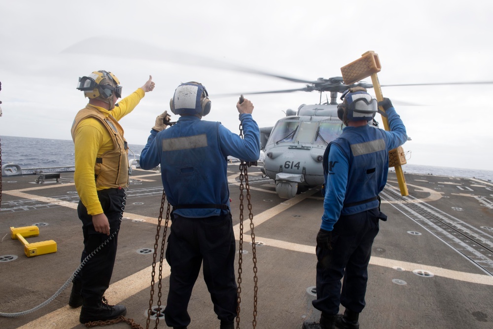 Sailors present chocks and chains to the pilot of an MH-60S Sea Hawk, with the Helicopter Sea Combat Squadron (HSC) 14, during flight operations aboard USS Spruance (DDG 111).