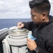 Quartermaster 3rd Class Vhlake Abangan records a gyro error on the compass of a telescopic alidade after shooting an azimuth on the bridge wing of USS Spruance (DDG 111).