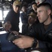 Gunner’s Mate Seaman Dylan King, right, operates the remote operation console (ROC) of a Mark 38 25 mm machine gun system while receiving training from Gunner’s Mate 2nd Class Brandon Diep, left, in the pilot house aboard USS Spruance (DDG 111).