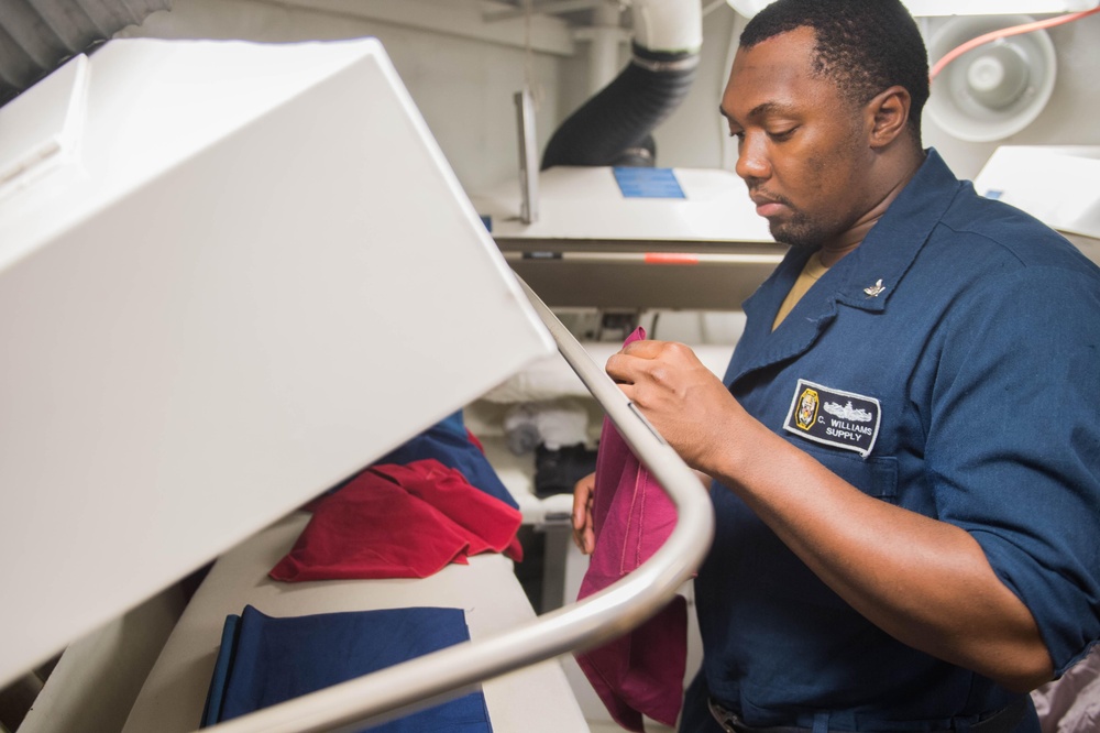 Ship’s Serviceman 3rd Class Corey Williams presses napkins for the mess decks aboard USS Mobile Bay (CG 53).