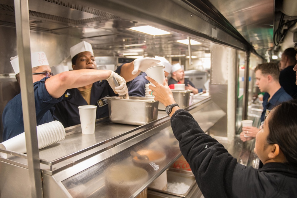 Sailors serve ice cream to fellow shipmates as part of an ice cream social aboard USS Mobile Bay (CG 53).