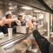 Sailors serve ice cream to fellow shipmates as part of an ice cream social aboard USS Mobile Bay (CG 53).