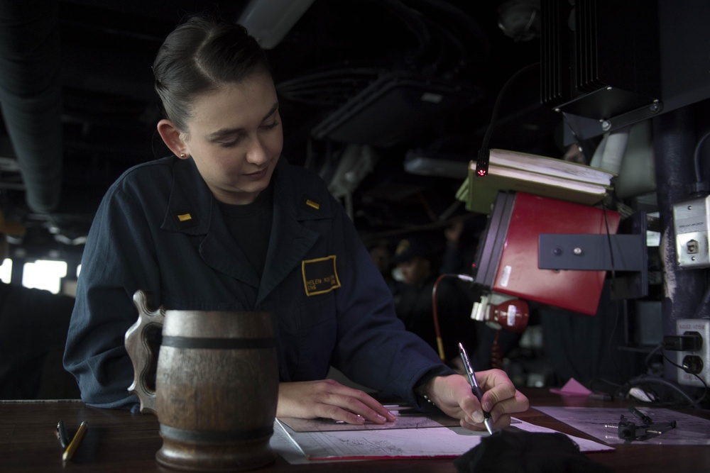 Ens. Helen Robertson completes a maneuvering board solution while standing watch as the junior officer of the deck (JOOD) in the pilot house aboard USS Spruance (DDG 111).