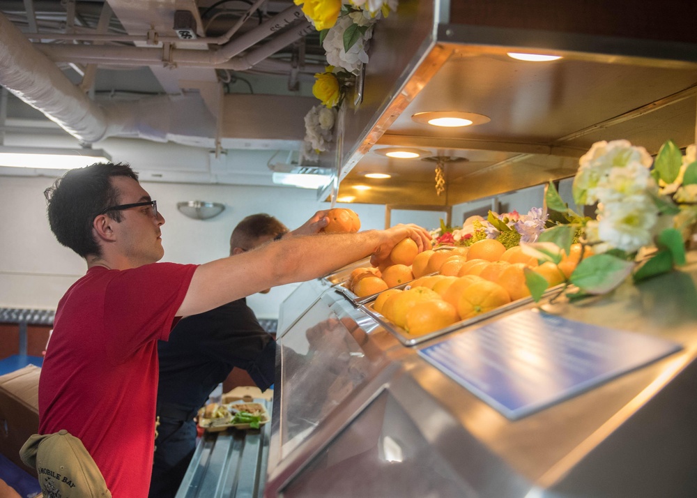 Sonar Technician (Surface) 3rd Class Austin Pyrz stocks fruit on the mess deck aboard USS Mobile Bay (CG 53).