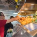 Sonar Technician (Surface) 3rd Class Austin Pyrz stocks fruit on the mess deck aboard USS Mobile Bay (CG 53).