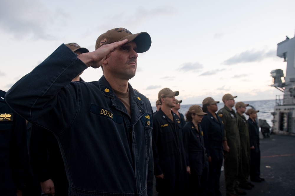 Cmdr. Ryan Doyle salutes for the national anthem during a change of command ceremony aboard USS Stockdale (DDG 106).