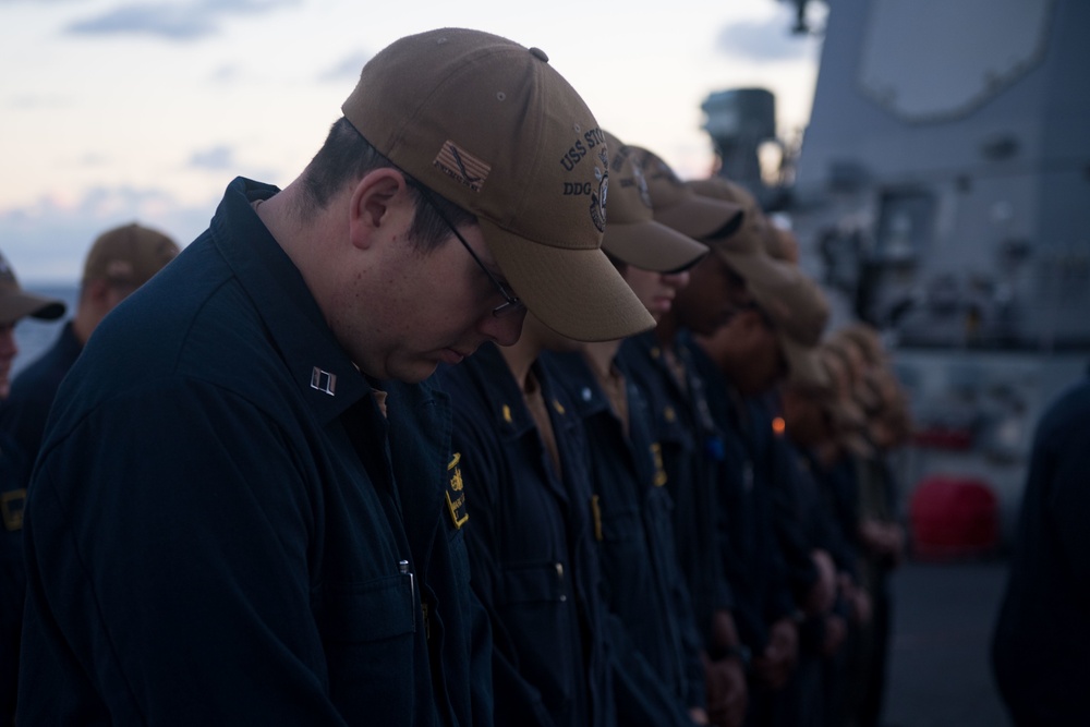 Lt. Mark Brandau bows his head for the invocation during a change of command ceremony aboard USS Stockdale (DDG 106).