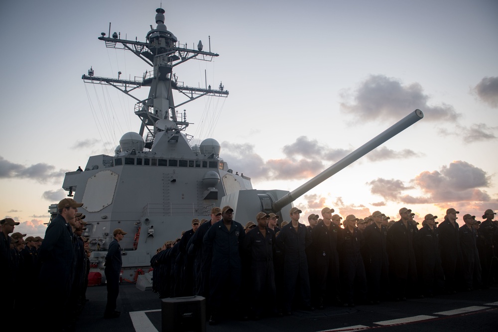 Sailors aboard USS Stockdale (DDG 106) stand at parade rest during a change of command ceremony.