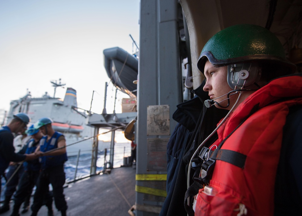 Petty Officer 3rd Class Christopher Stollings serves as a communicator during a replenishment-at-sea aboard USS Mobile Bay (CG 53).
