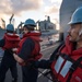 Information Systems Technician 1st Class Rene Acosta handles a communication line during a replenishment-at-sea aboard USS Mobile Bay (CG 53).