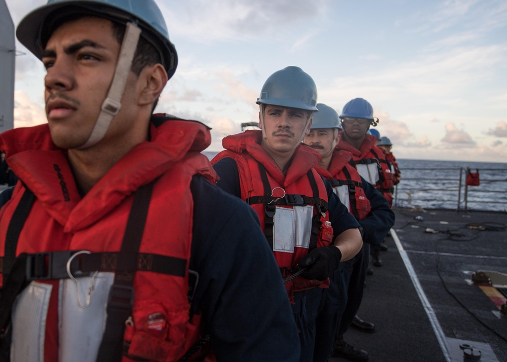 Sailors handle a communication line during a replenishment-at-sea aboard USS Mobile Bay (CG 53).