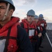 Sailors handle a communication line during a replenishment-at-sea aboard USS Mobile Bay (CG 53).