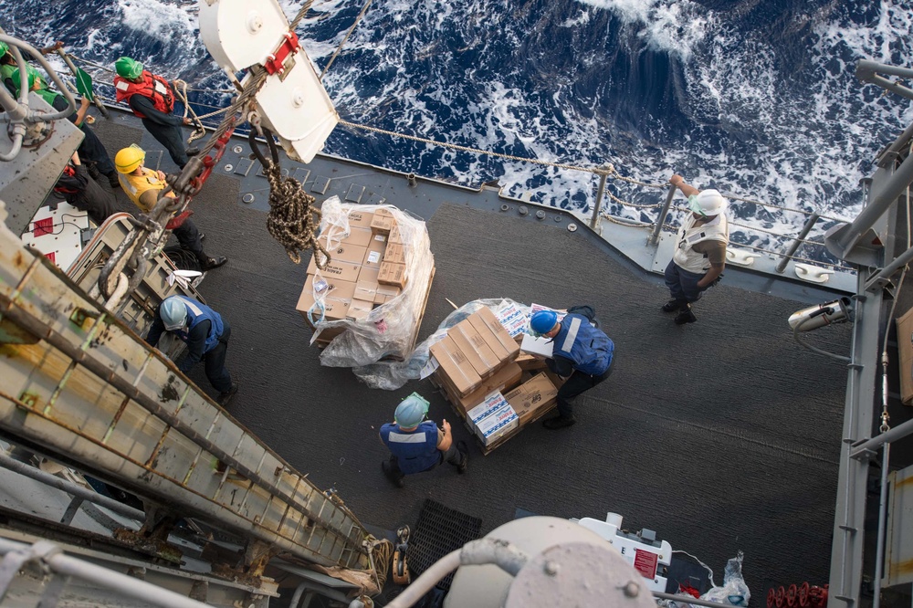 Sailors unload pallets of supplies during a replenishment-at-sea USNS Guadalupe (T-AO 200) aboard USS Mobile Bay (CG 53).