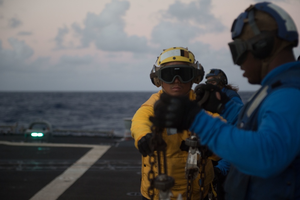 Boatswain’s Mate 2nd Class Melvin Bergado inspects chains after their removal from an MH-60R Sea Hawk during flight deck operations aboard USS Chung-Hoon (DDG 93).
