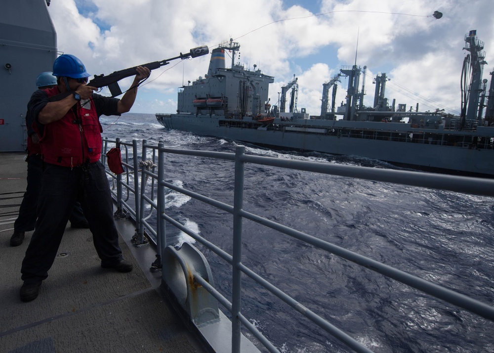 Gunner's Mate 3rd Class Daniel Zhang fires a shot line to USNS Guadalupe (T-AO 200) during a replenishment-at-sea (RAS) aboard  USS Mobile Bay (CG 53).