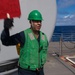 Seaman Anthony Zanbrano, from Fresno, California, signals to USNS Guadalupe (T-AO 200) during a replenishment-at-sea aboard USS Mobile Bay (CG 53).