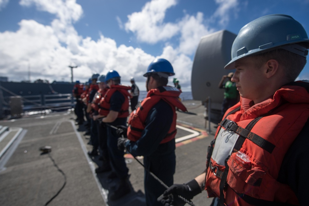 Sonar Technician (Surface) Nick Herman handles the phone and distance line aboard USS Mobile Bay (CG 53) during a replenishment-at-sea.