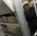 Information Systems Technician 3rd Class Marshon Wade dusts a ladderwell during cleaning stations aboard USS Spruance (DDG 111).