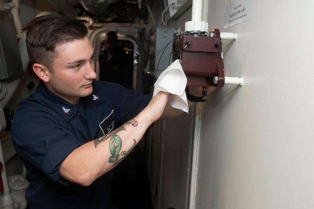 Hospital Corpsman 3rd Class C.J. Lake wipes down a casualty power terminal during cleaning stations aboard  USS Spruance (DDG 111).