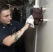 Hospital Corpsman 3rd Class C.J. Lake wipes down a casualty power terminal during cleaning stations aboard  USS Spruance (DDG 111).