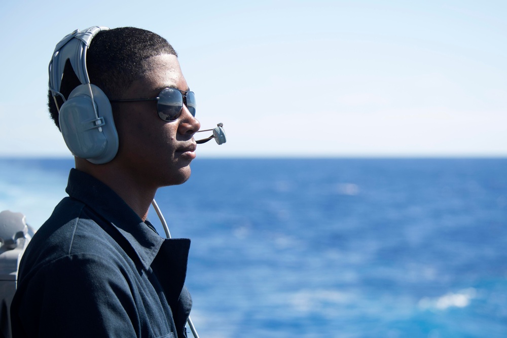 Logistics Specialist Seaman Isaiah Anthony stands watch as a forward lookout aboard USS Spruance (DDG 111).