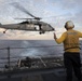 Boatswain’s Mate 2nd Class Brian Bruni signals the pilot of an MH-60S Sea Hawk during a vertical replenishment.