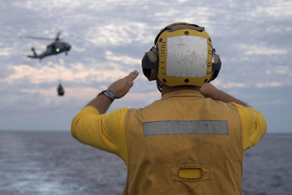 Boatswain’s Mate 2nd Class Brian Bruni signals the pilot of an MH-60S Sea Hawk during a vertical replenishment.