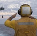 Boatswain’s Mate 2nd Class Brian Bruni signals the pilot of an MH-60S Sea Hawk during a vertical replenishment.