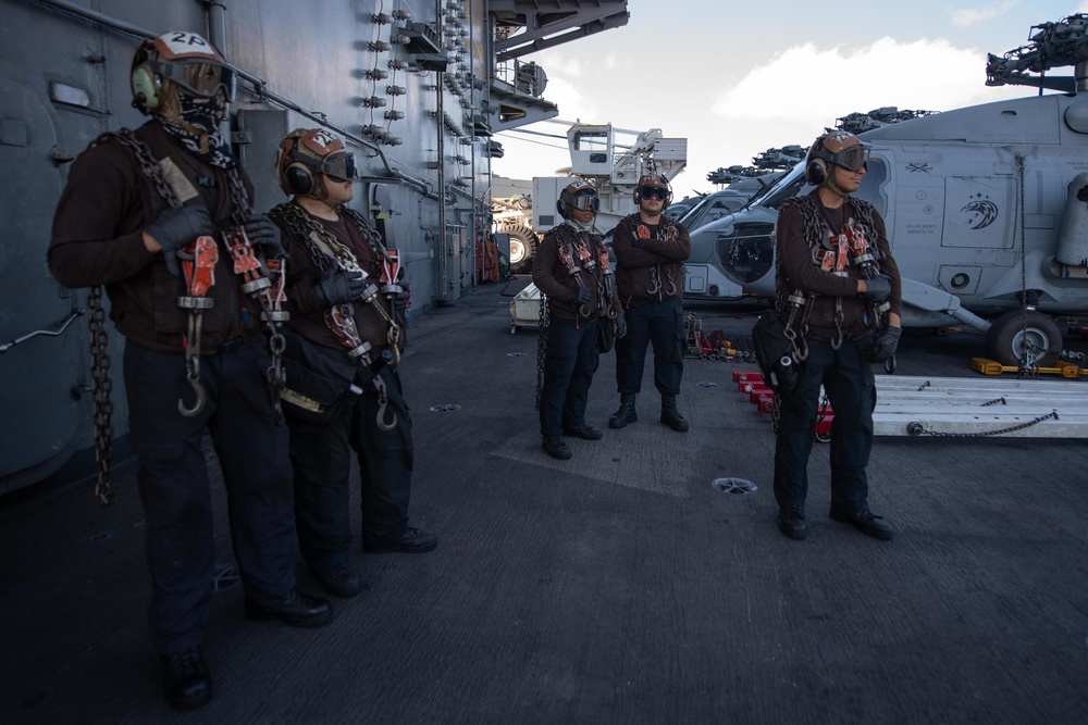 Sailors stand by to secure aircraft with chains during flight operations on the flight deck aboard USS John C. Stennis (CVN 74).