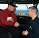 Aviation Ordnanceman 3rd Class Dylan Drake receives a coin for his selection as the USS John C. Stennis (CVN 74) Sailor of the Day from Capt. Randy Peck, commanding officer of John C. Stennis.