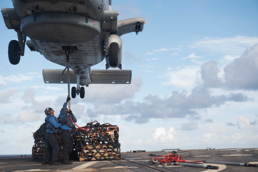 Sailors attach pallets to an MH-60R Sea Hawk, with Helicopter Maritime Strike Squadron 37, aboard USS Chung-Hoon (DDG 93) during a vertical replenishment.