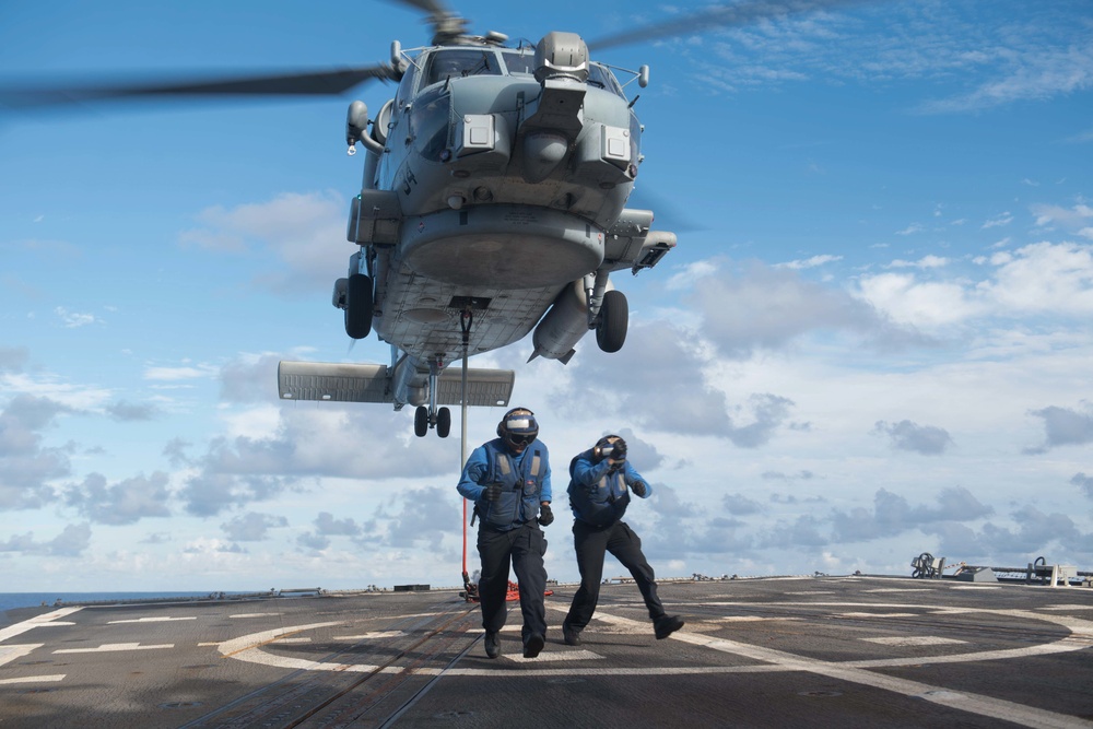 Sailors return to the foul line after attaching cargo to an MH-60R Sea Hawk, with Helicopter Maritime Strike Squadron 37, aboard USS Chung-Hoon (DDG 93) during a vertical replenishment.