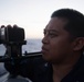 Logistics Specialist 2nd Class Michael Pescador uses a video camera during a visual information drill aboard USS Chung-Hoon (DDG 93).