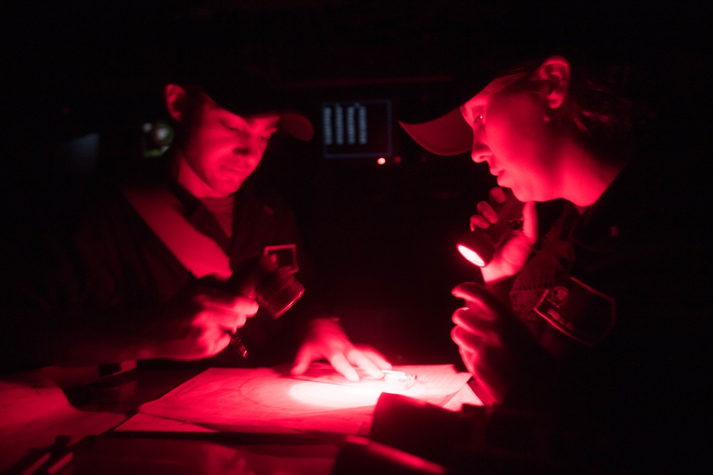 Ens. Eileen Sullivan, right, and Ens. Thomas Sarant use a maneuvering board in the pilothouse of USS Chung-Hoon (DDG 93).