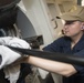 Sonar Technician (Surface) Seaman Kennison Cochran uses rags to dry the cable while retrieving the multifunction towed array (MFTA) aboard USS Spruance (DDG 111).